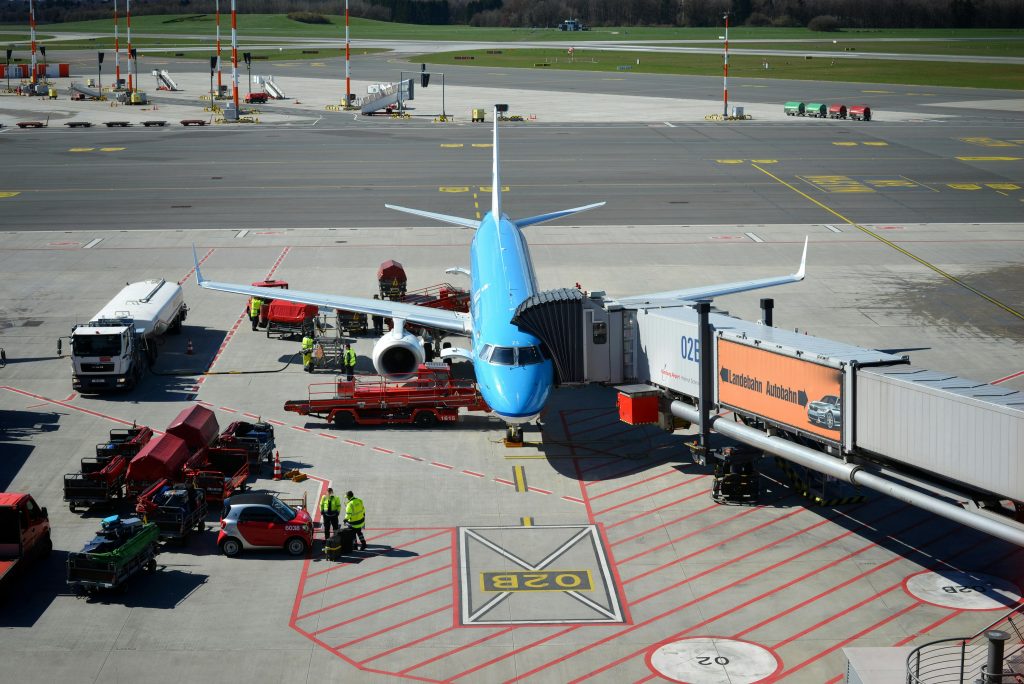 A commercial airplane on the tarmac connected to an airport gate, ready for boarding.